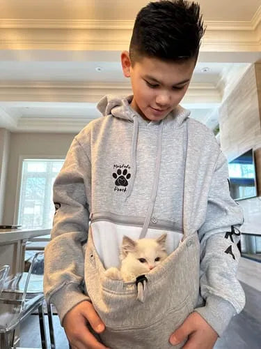 A kitten nestled in the front pouch of a Muskoka Pooch Hoodie